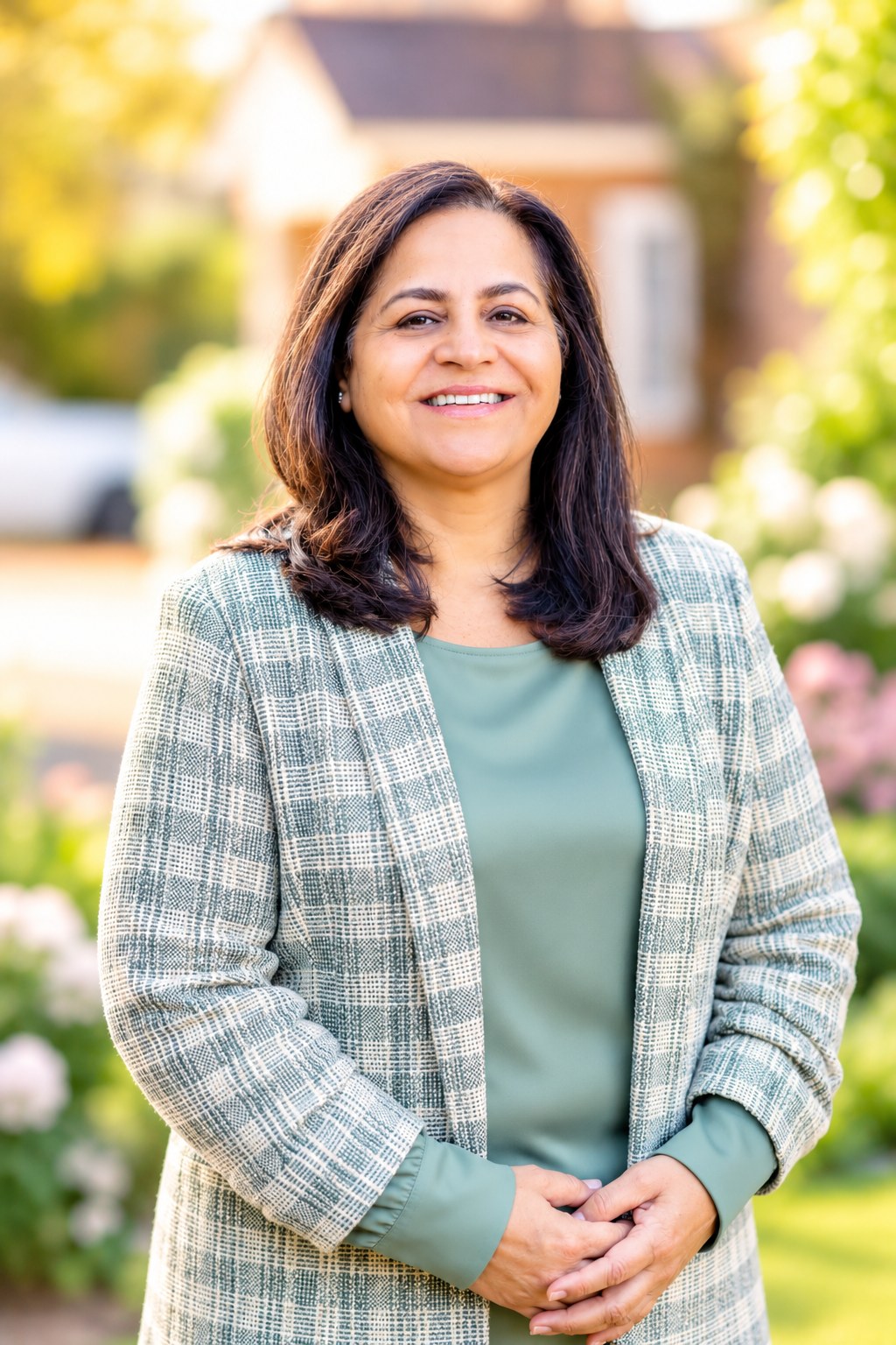 Portrait of Mani Bajwa outdoors wearing soft sage-green clothing